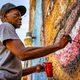 BRUNSWICK, GEORGIA / USA - May 14, 2020: Artist Marvin Weeks paints a mural of Ahmaud Arbery, who was shot to death in Glynn County, Georgia, on February 23, 2020.